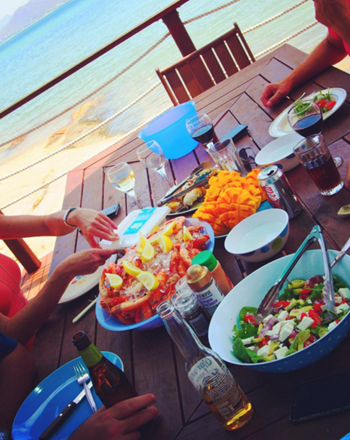 MATW-Copiar-imagen.png Gente almorzando en la playa con mango en rodajas