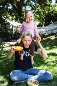 Mamá e hija en el parque comiendo mango