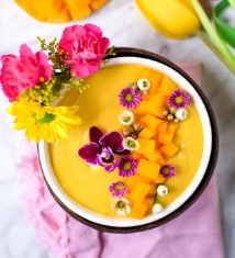 Tazón de licuado de mango primaveral con adelanto de flores comestibles