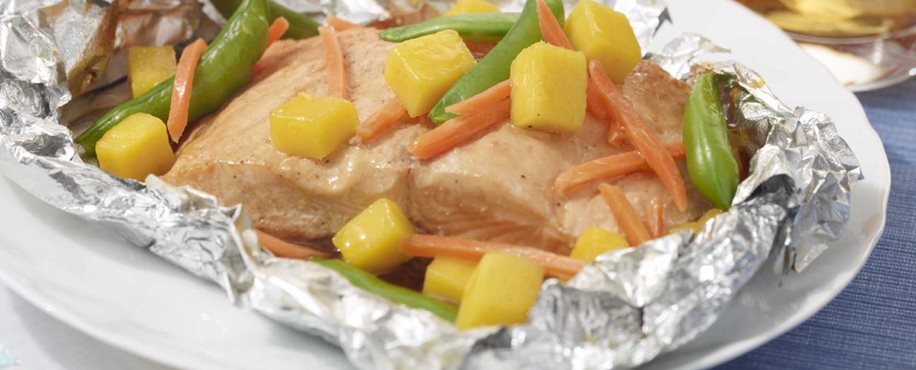 Salmón en paquetes de aluminio con mangos, zanahorias y guisantes dulces